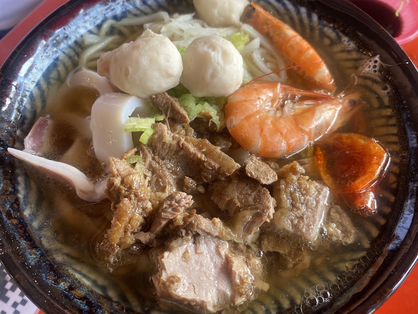 桌上有牛肉麵與海鮮配料的餐點畫面