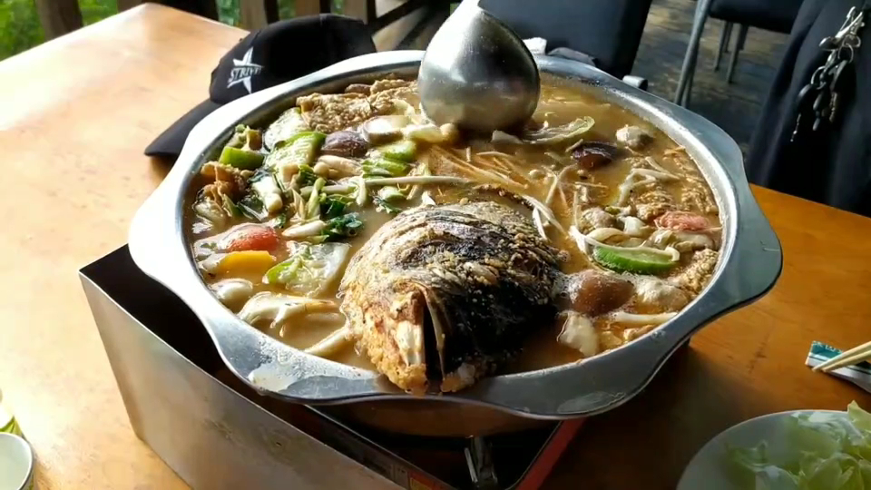 豐富的魚頭火鍋，鍋內有魚頭、蔬菜與香菇