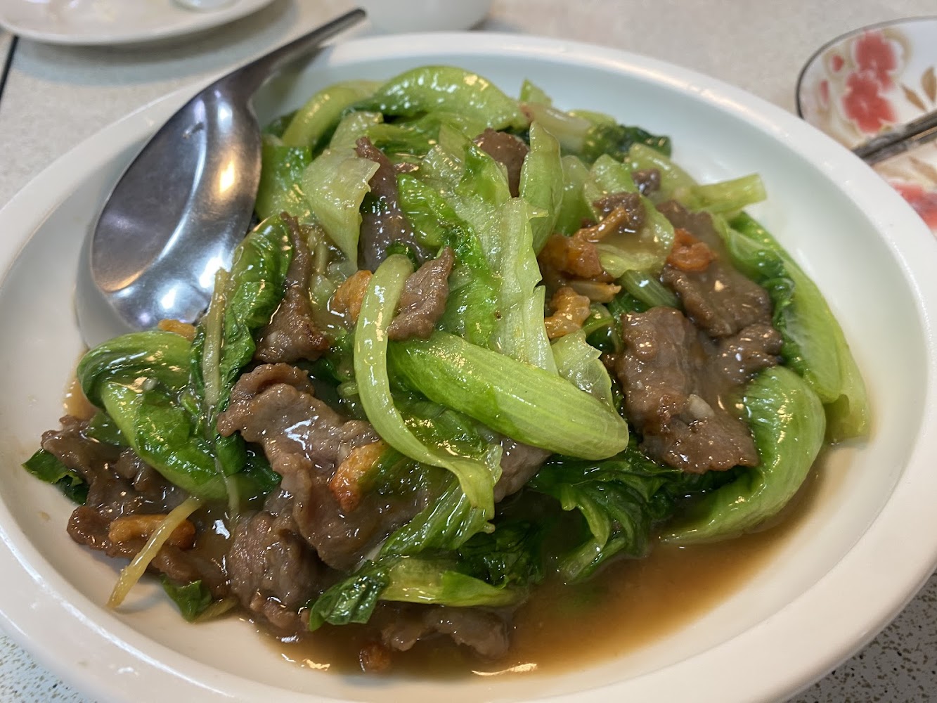 快炒牛肉與生菜，牛肉片和翠綠生菜拌炒在醬汁中