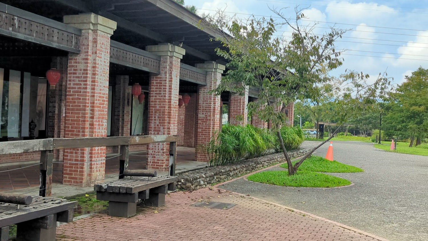 紅磚建築旁有長椅綠樹與燈籠