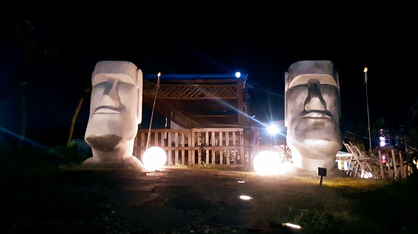 兩座摩艾石像仿製雕像，位於戶外夜間場景，周圍有球形燈光裝飾