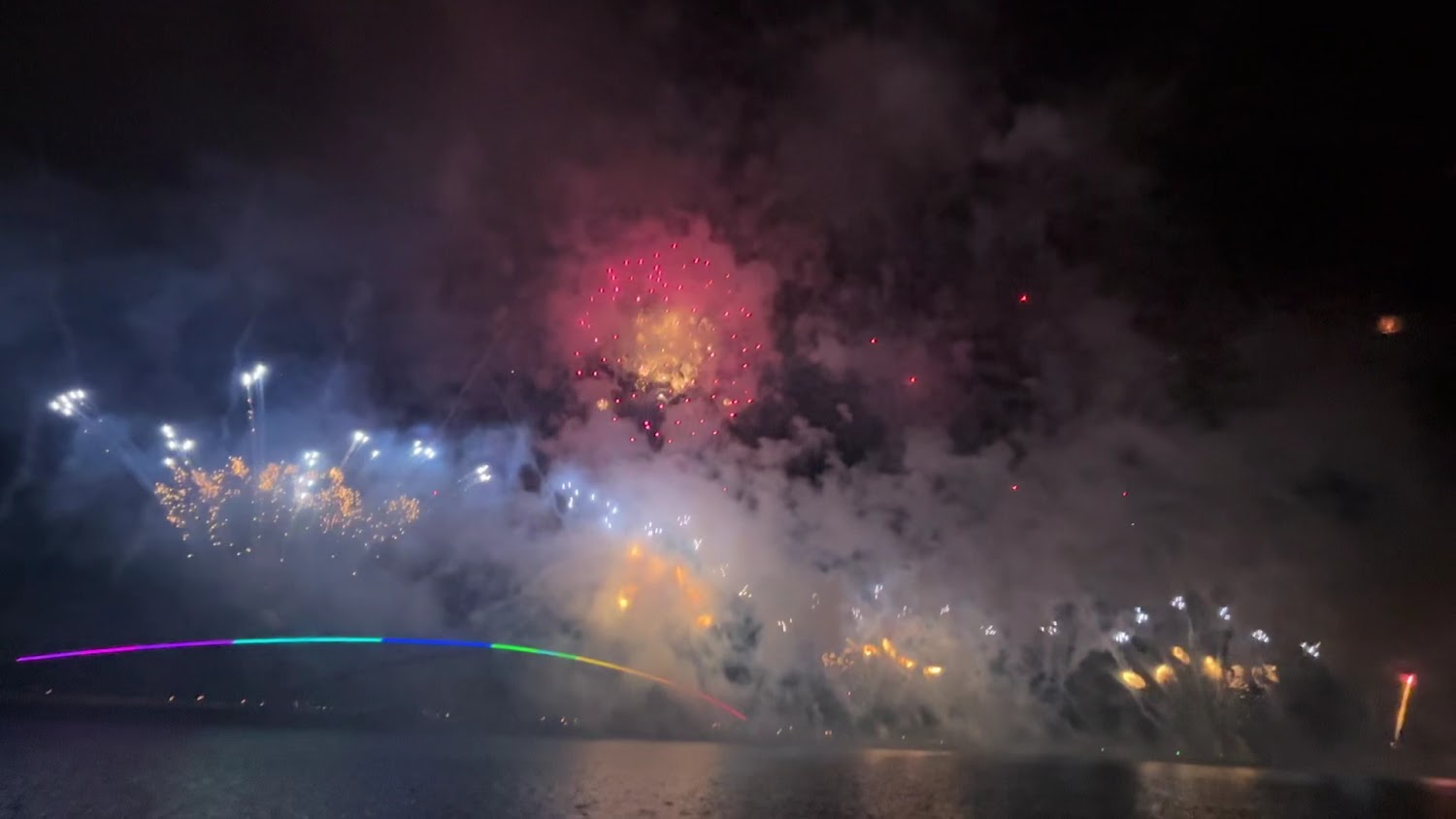 夜空煙火與彩色燈光橋交織的澎湖景色