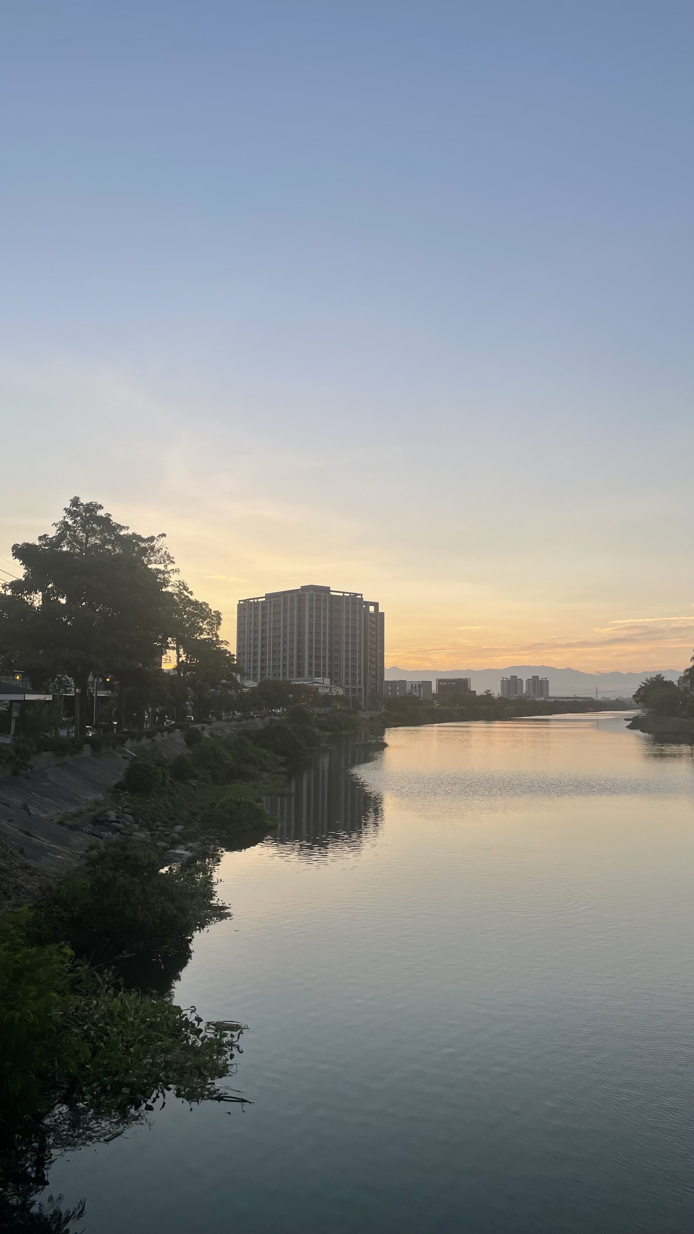 河流兩岸城市景觀與夕陽餘暉