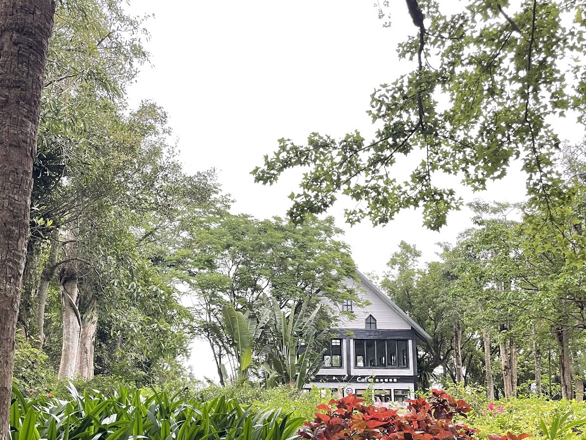 初鹿牧場森林咖啡館外觀，樹木花圃環繞的木屋建築