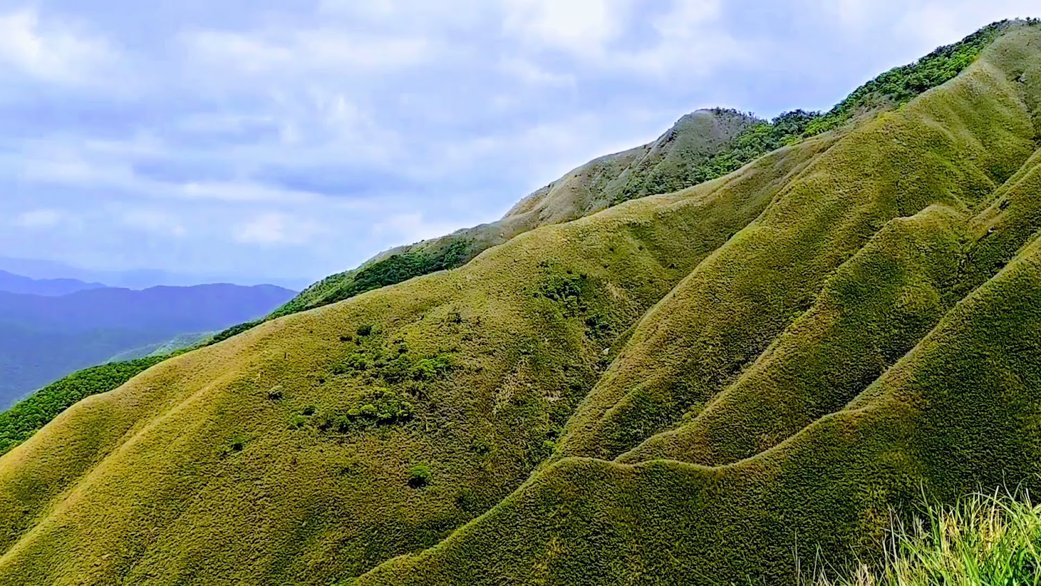 三角崙山綠色山巒與遠方山脈