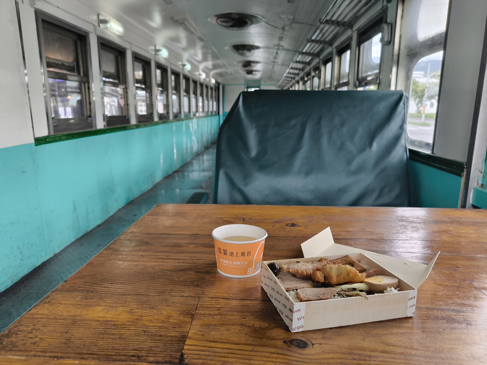 悟饕池上飯包復古火車車廂改造用餐區木桌飯包套餐橘色湯杯