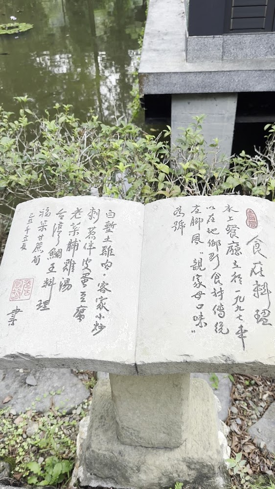 設有中文題字的石碑與池塘景觀