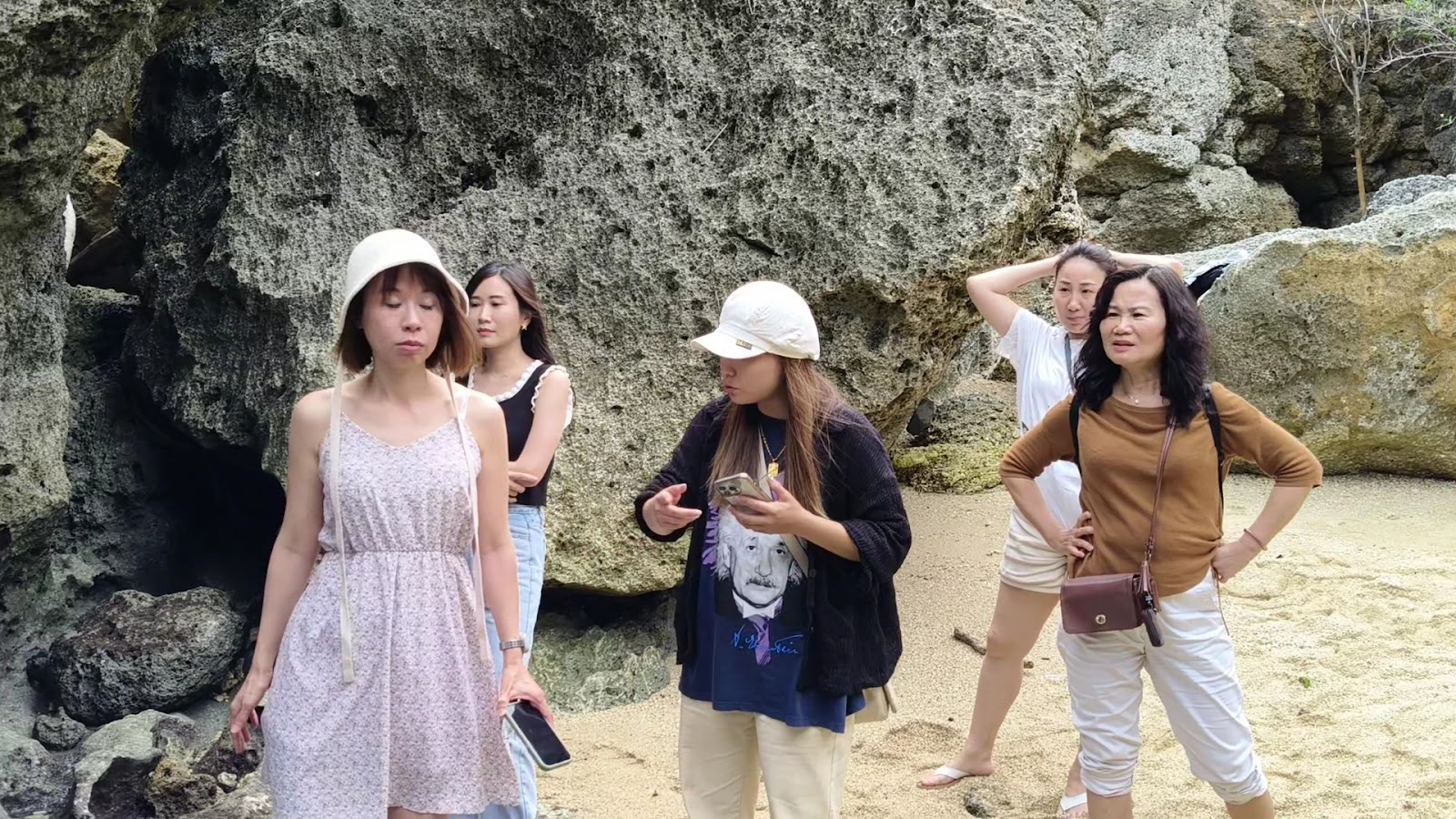 遊客在龍蝦洞礁岩洞穴旁探索
