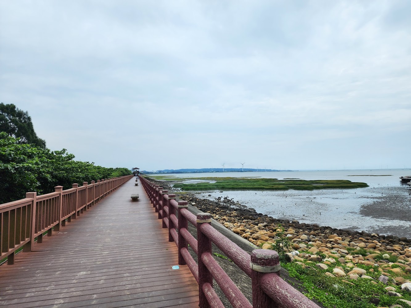 沿海紅色木棧道與遠方風機景色
