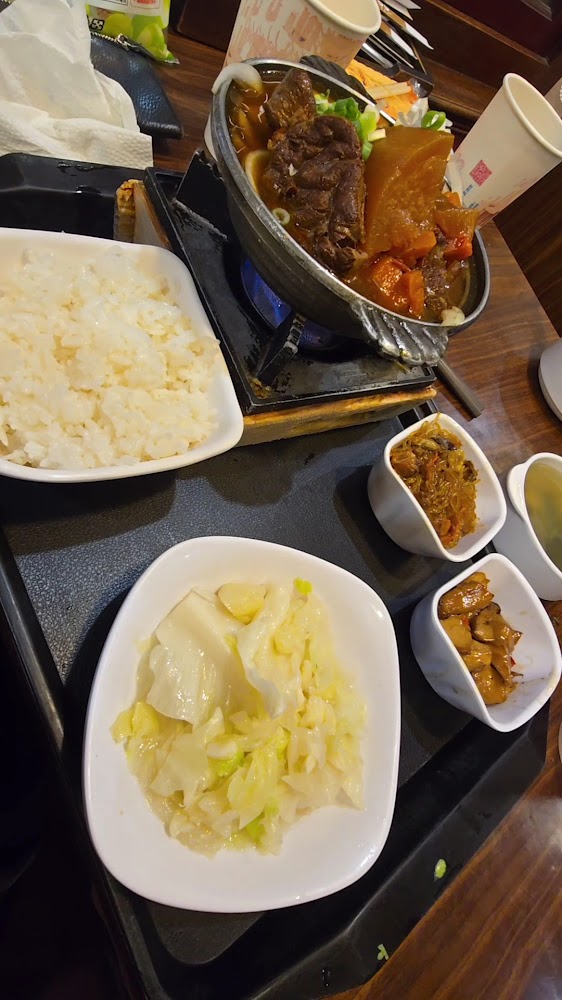 這張圖片主要是一份中式套餐，包括牛肉火鍋、白飯、燙青菜、三道小菜及一碗湯。餐點種類豐富，擺放整齊，看起來十分美味。