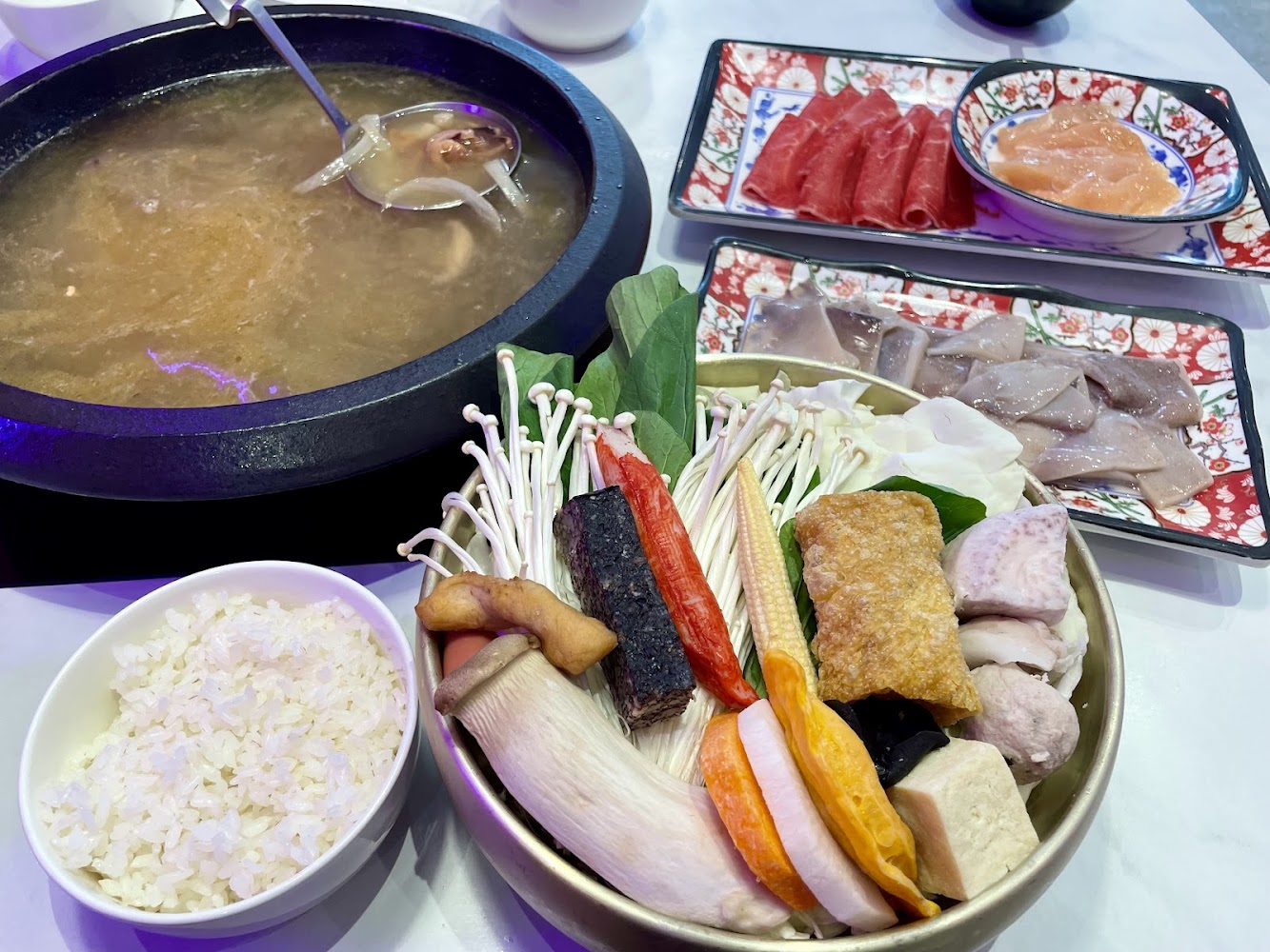 火鍋桌面擺滿蔬菜菇類豆腐肉片與海鮮料