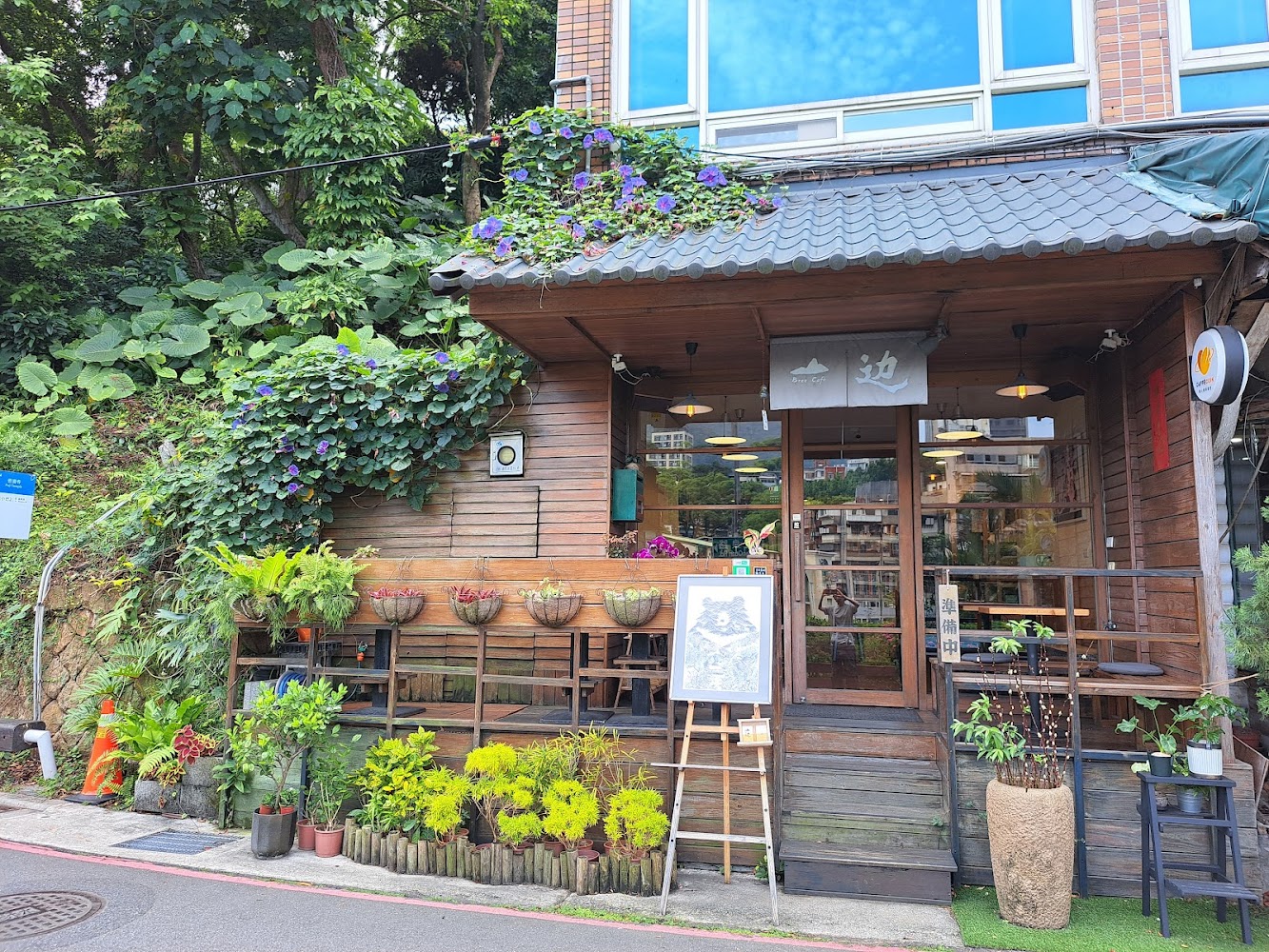 木質小屋咖啡館位在綠意環繞山坡上