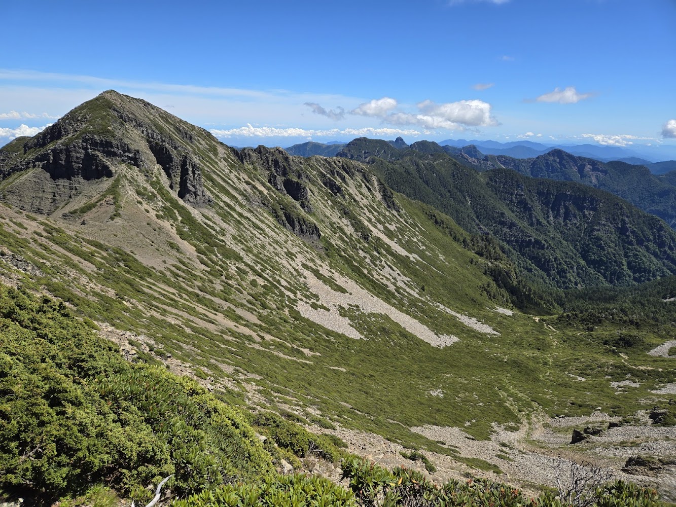 覆蓋翠綠植被的壯麗山峰與藍天白雲