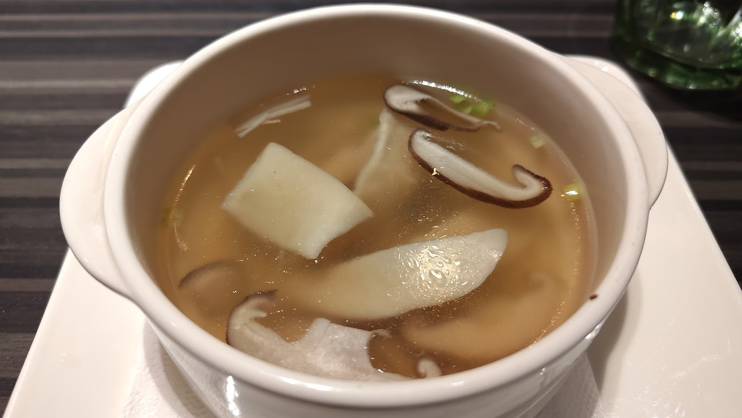 一碗清湯內有香菇與白蘿蔔片湯色清澈