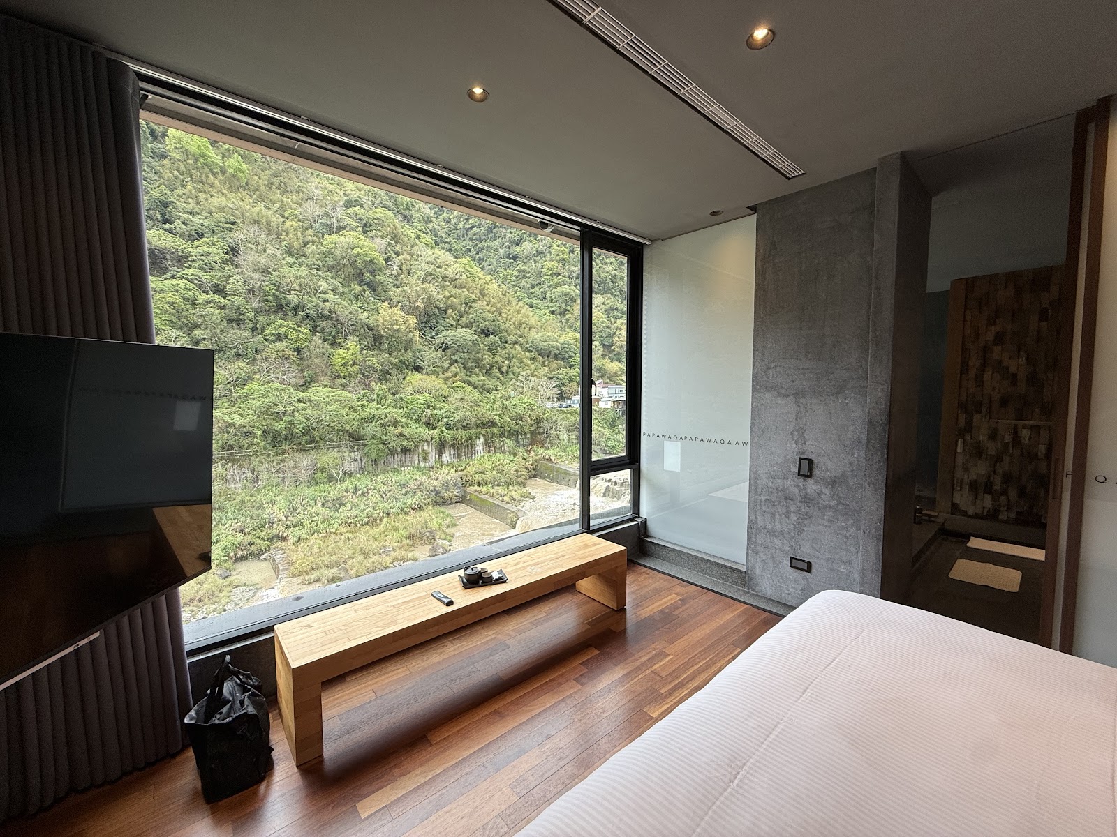 泰安觀止溫泉會館客房內景，落地窗俯瞰翠綠山谷，現代禪風設計