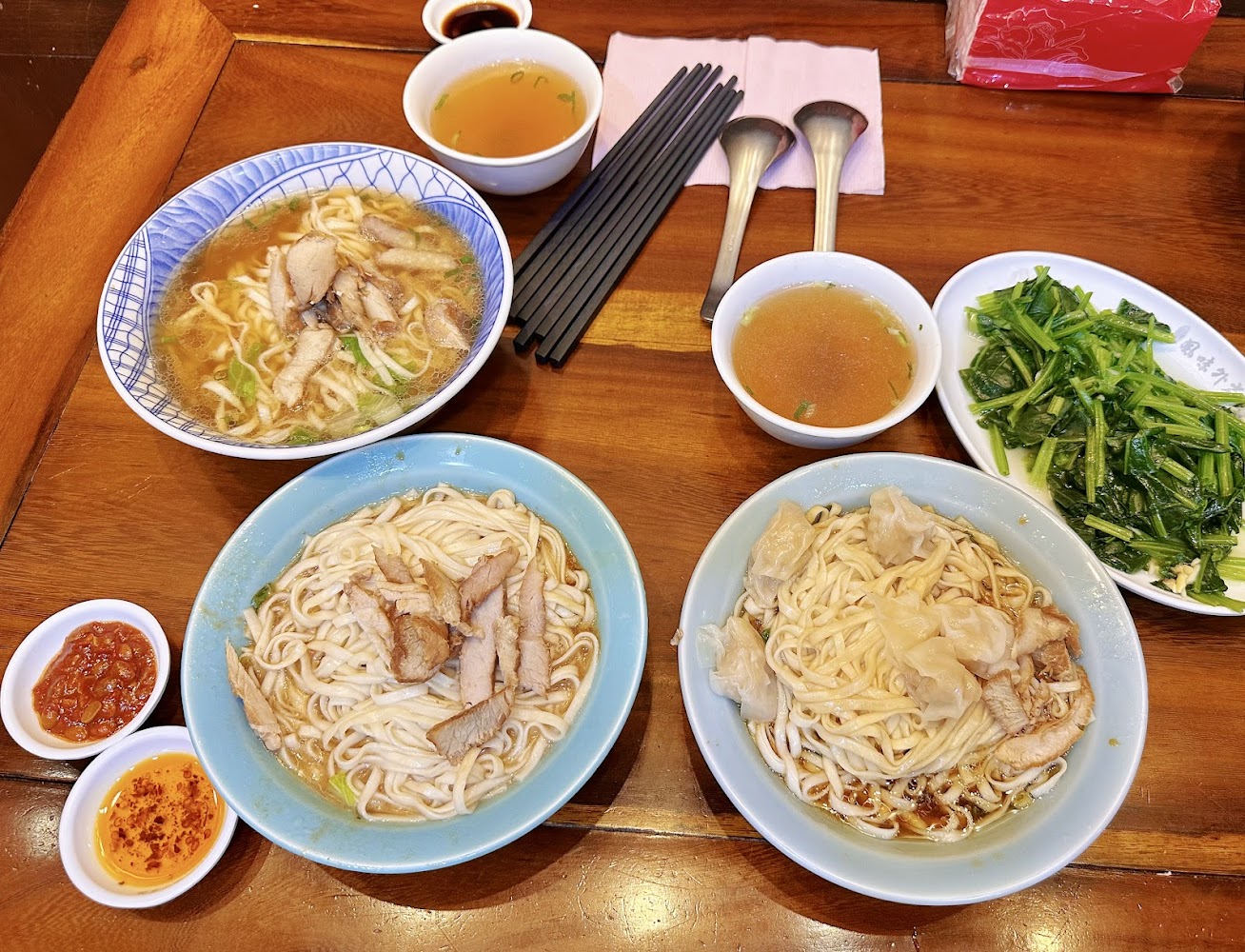 多人份餐點合照，三碗麵搭配燙青菜湯品與辣醬