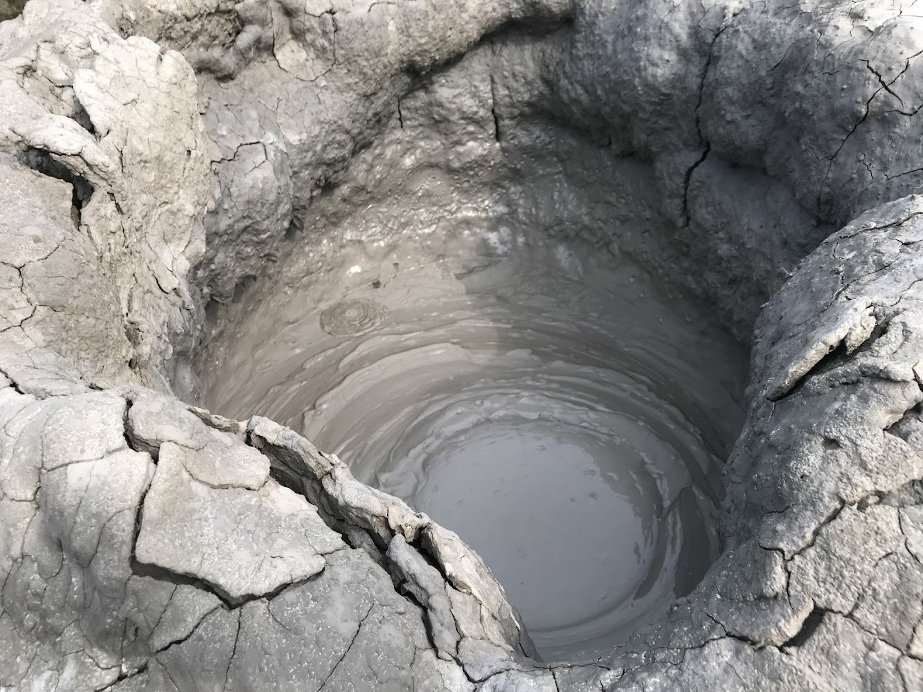 泥火山泥池中央有灰色泥漿冒泡