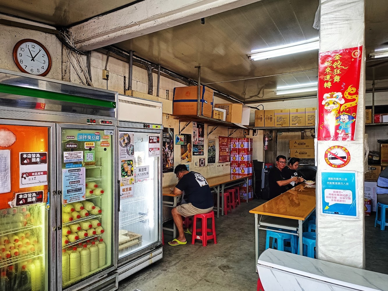 店內有多台冷藏櫃與木桌塑膠凳，客人正在用餐