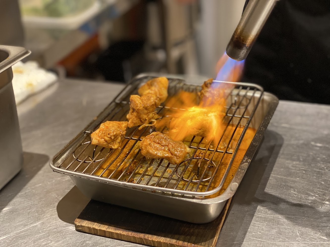 使用噴槍炙燒肉塊的料理過程