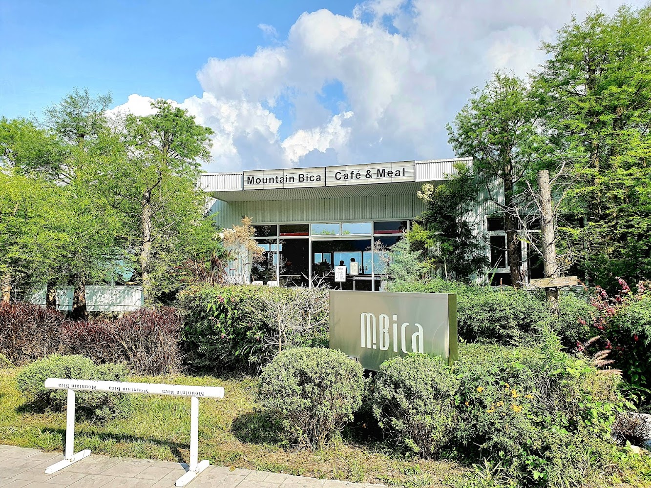 戶外拍攝的Mountain Bica Café & Meal外觀，建築被綠樹和灌木環繞