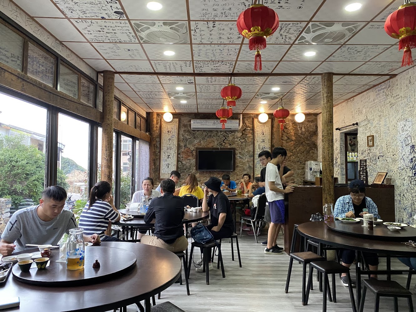 依嬤的店室內空間，紅燈籠高掛，圓桌和滿牆留言充滿熱鬧氛圍