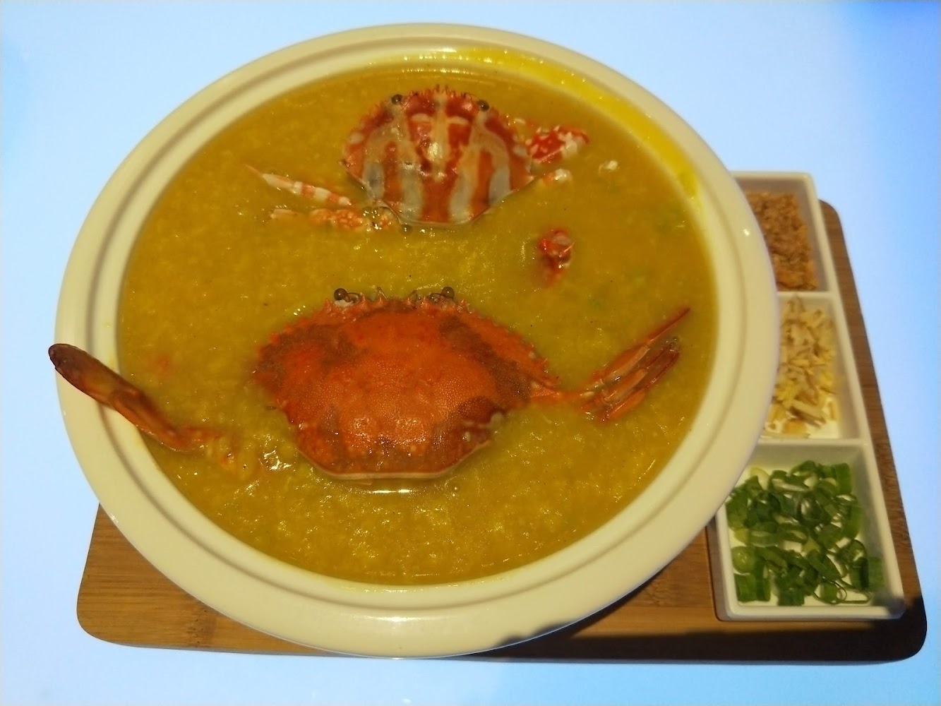 海洋微光螃蟹粥特寫與蔥花炸蒜等配料