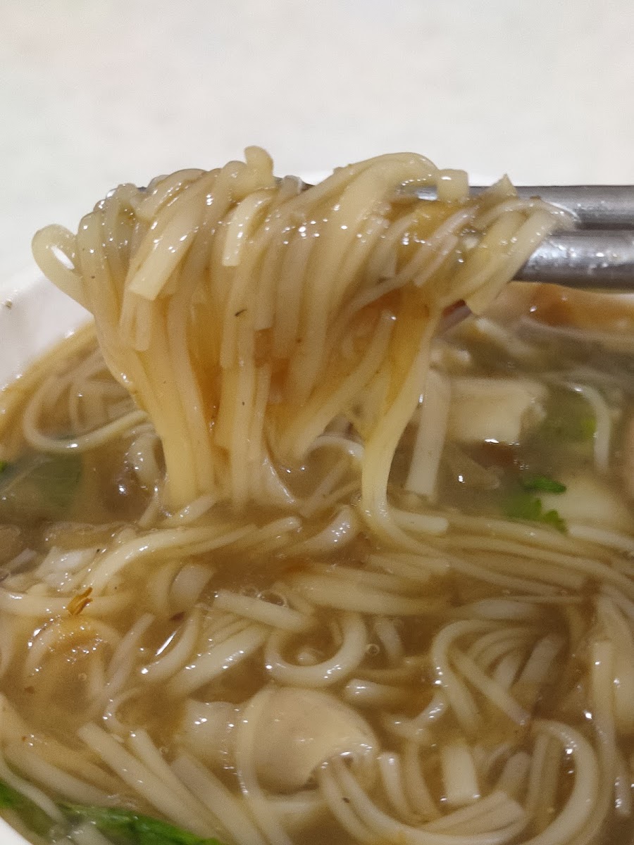阿宗麵線麵線特寫，筷子夾起一束麵線，棕色濃郁芡汁滴落
