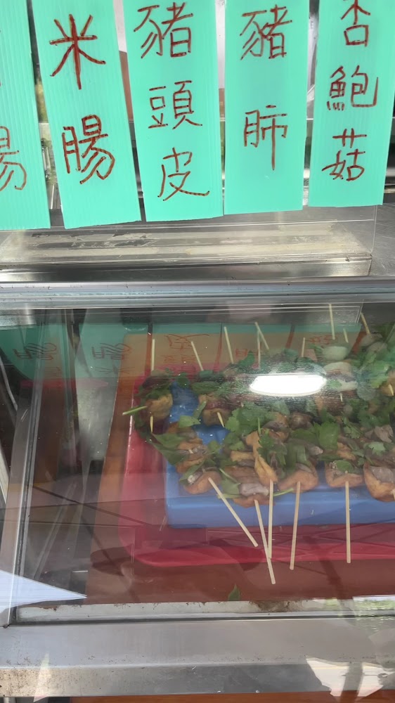 攤位綠色招牌與串好的熟食