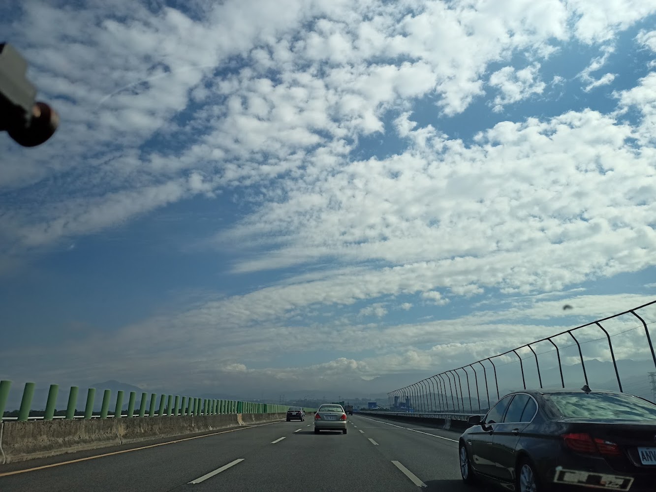 高速公路上車輛行駛,遠方山脈與晴朗天空相映
