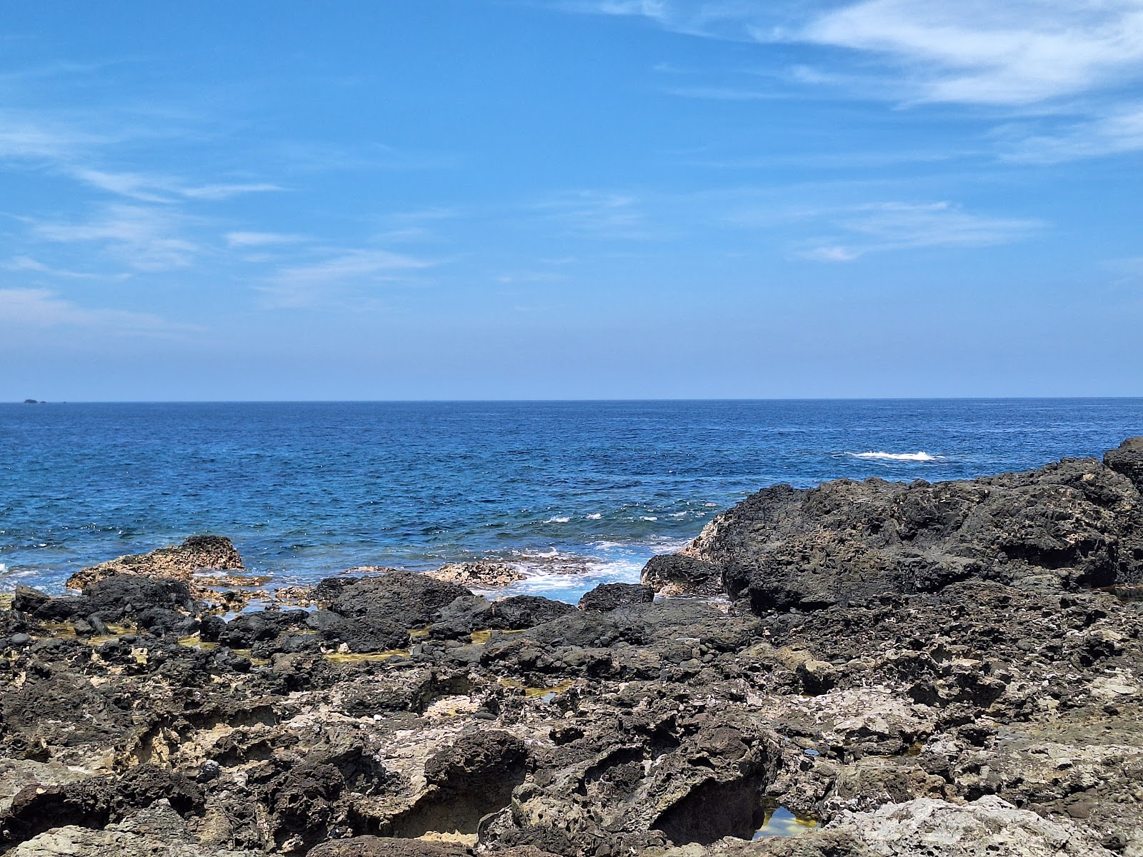 柚子湖玄武岩礁石海岸,黑色礁岩與深藍海水形成強烈對比