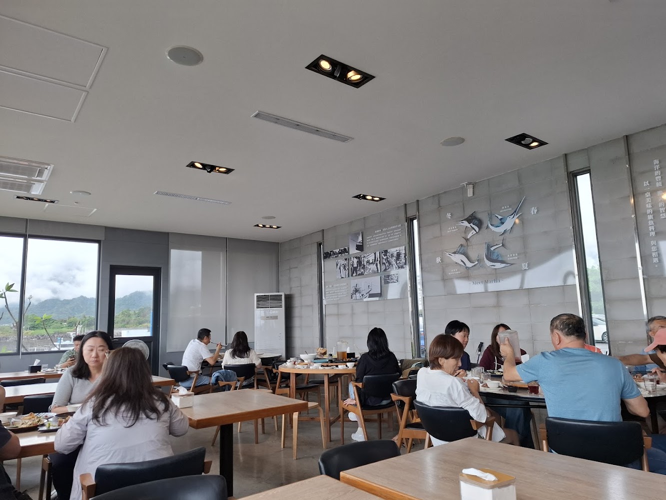 旗遇海味室內用餐空間明亮，可見窗外山景與舒適座位