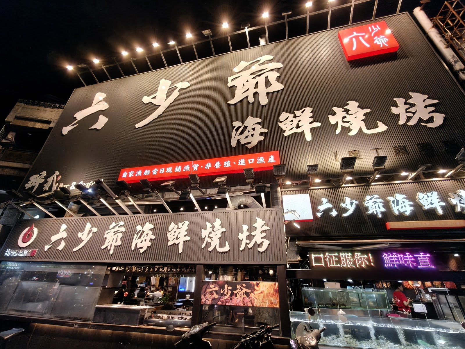 墾丁大街海鮮燒烤店夜晚燈火通明招牌