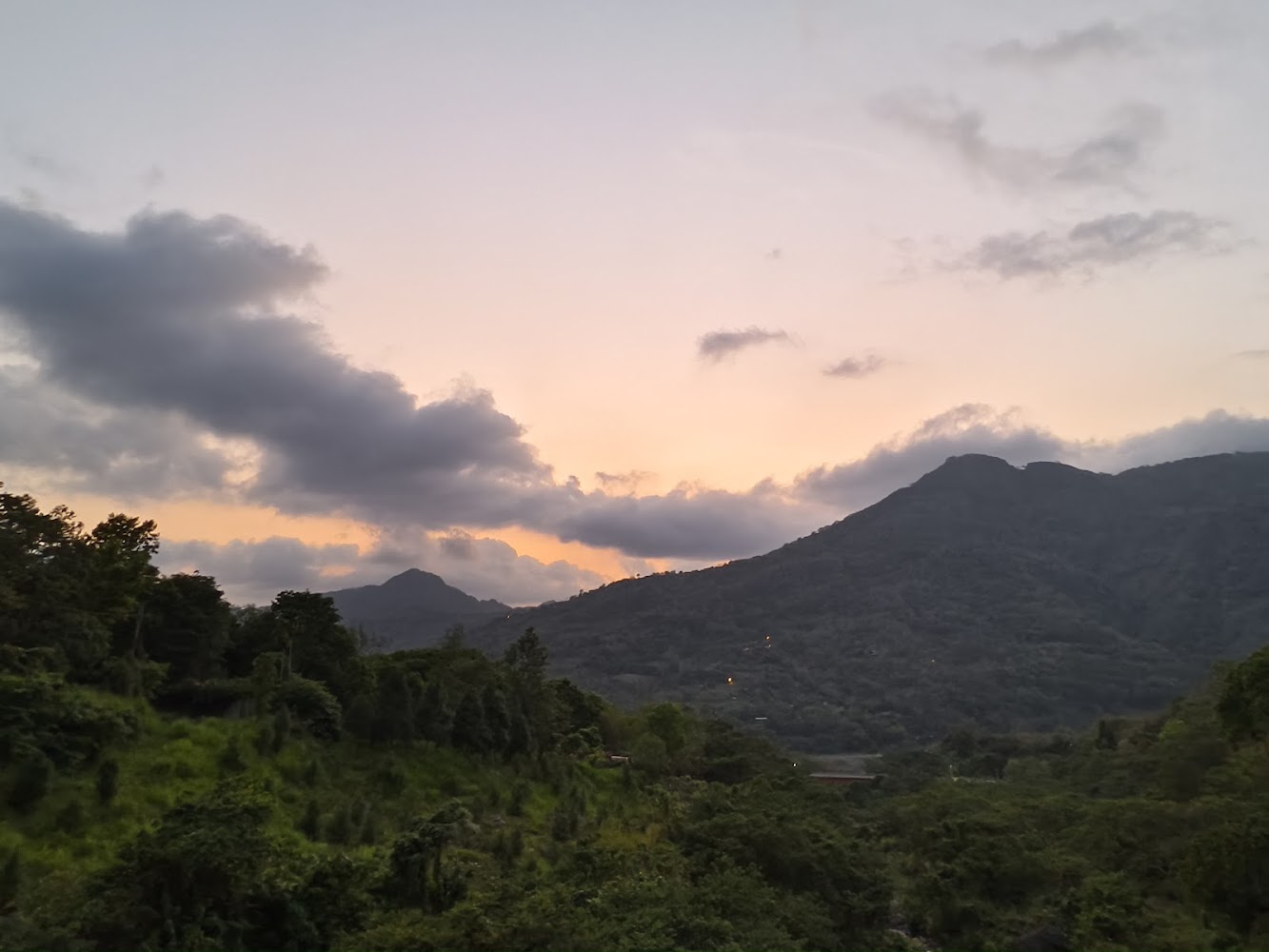 綠色森林遠望山脈與夕陽餘暉