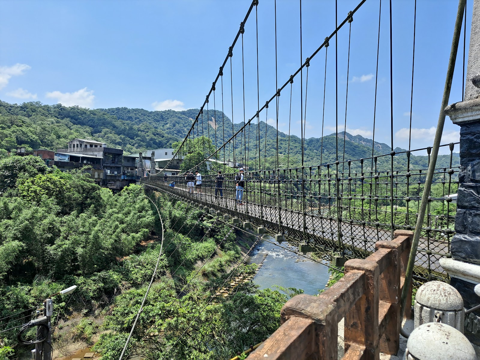 靜安吊橋全景，橫跨基隆河兩岸山色蒼翠