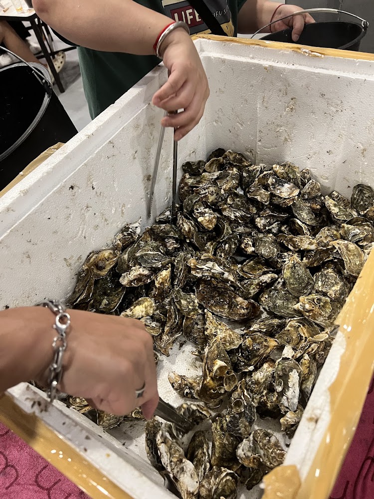 客人以夾子夾取保麗龍箱內生蠔
