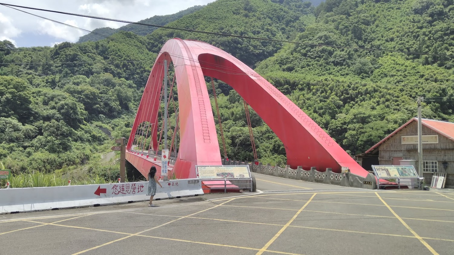 鮮紅色拱橋橫跨綠意盎然山谷