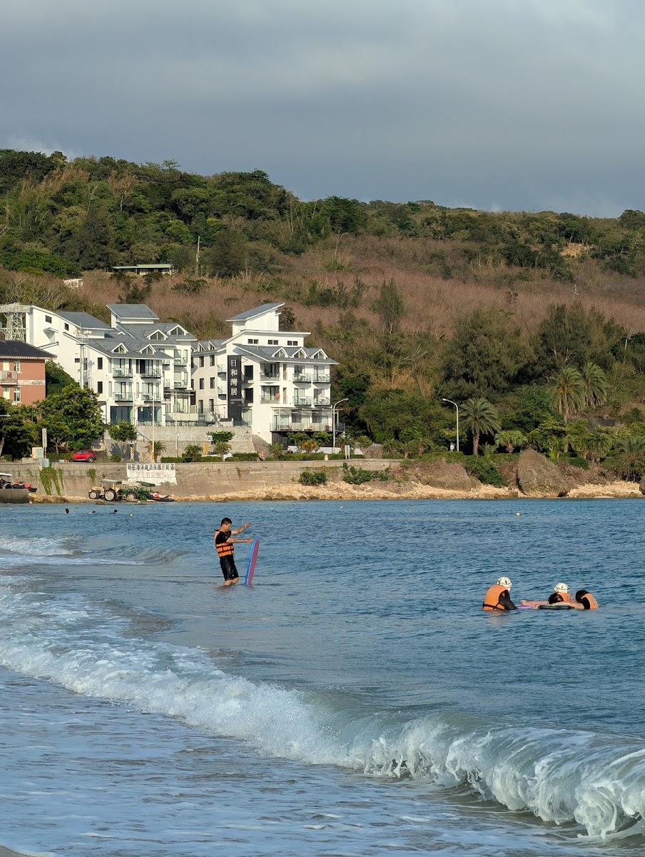南灣沙灘遊客嬉戲，海浪輕拍沙岸