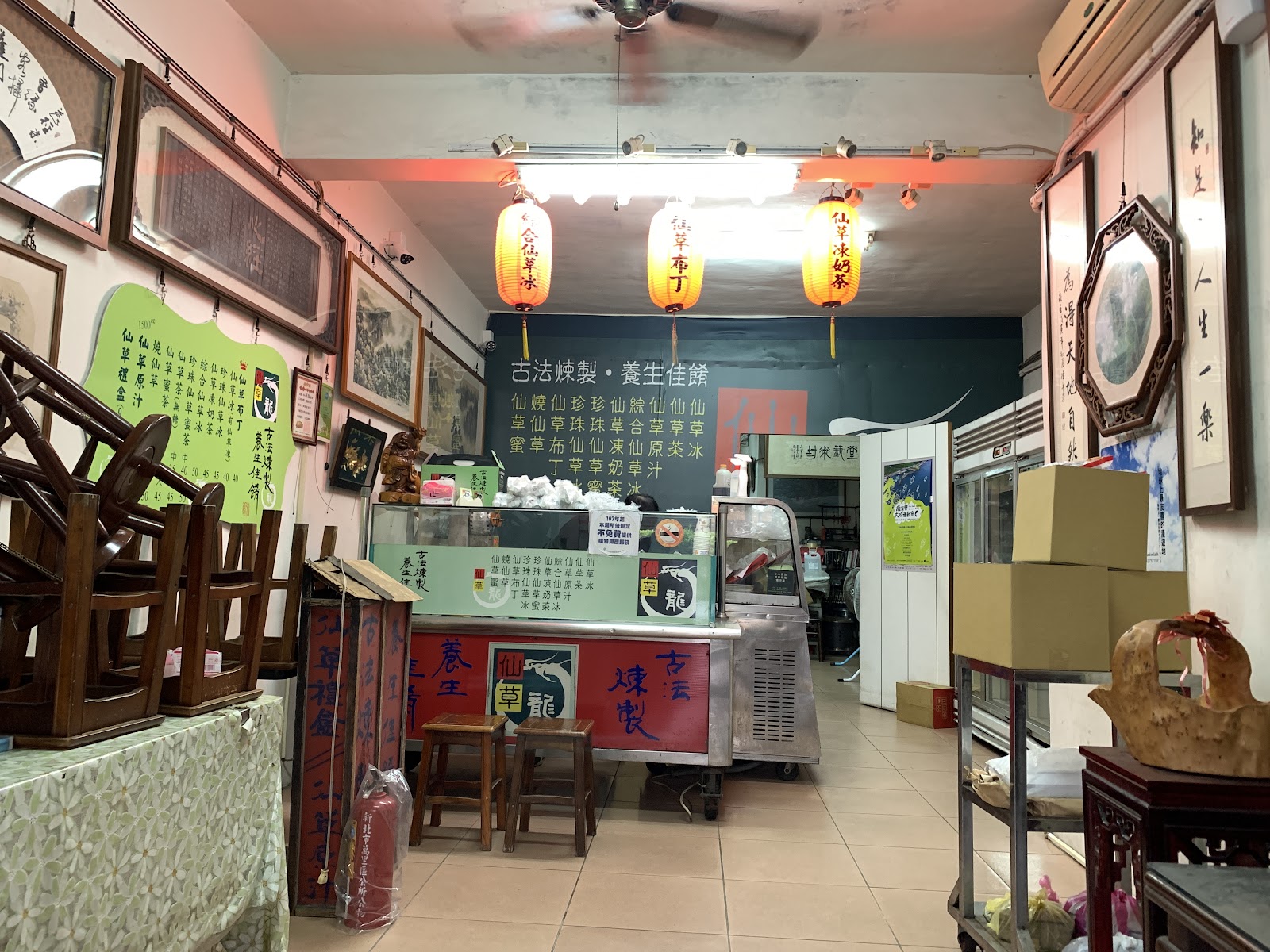 仙草龍店內全景，燈籠高掛，書法字畫裝飾牆面，木桌椅古色古香