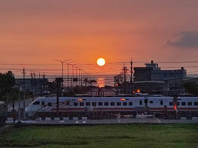 夕陽下行進中的火車與晚霞