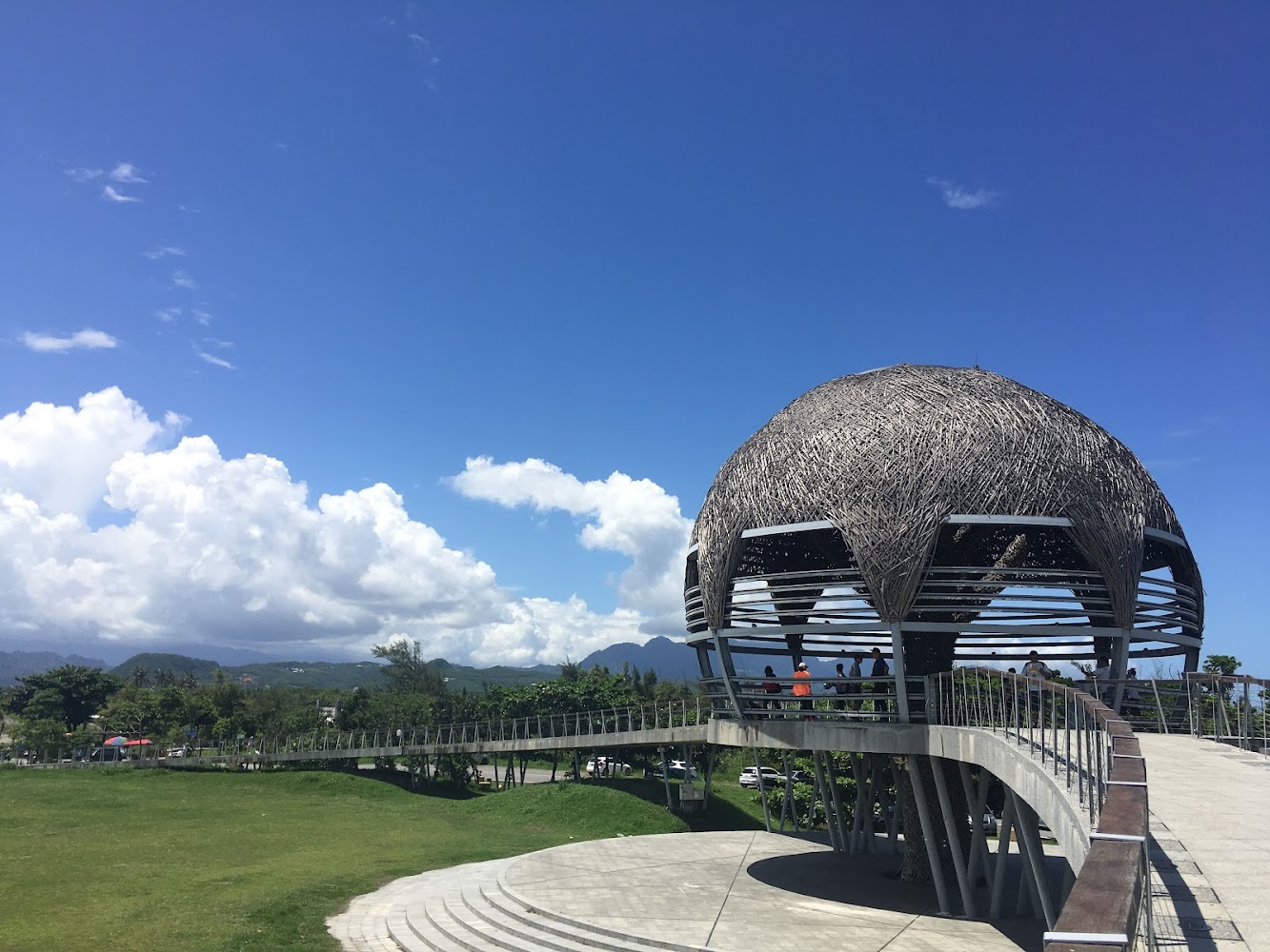 鳥巢造型觀景台位於草地上藍天白雲背景