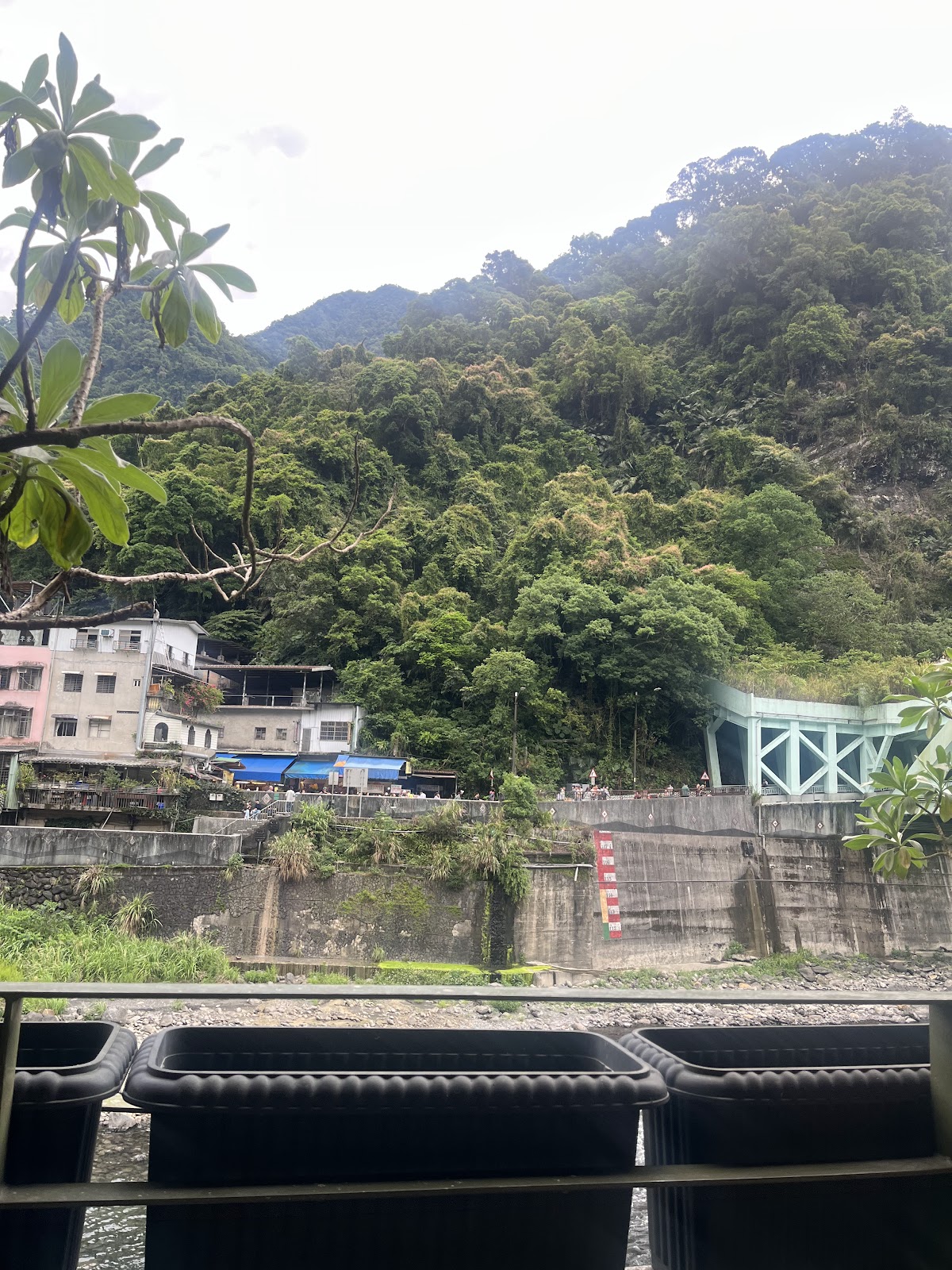 烏來水岸溫泉飯店日間景觀，俯瞰南勢溪與情人橋遠景
