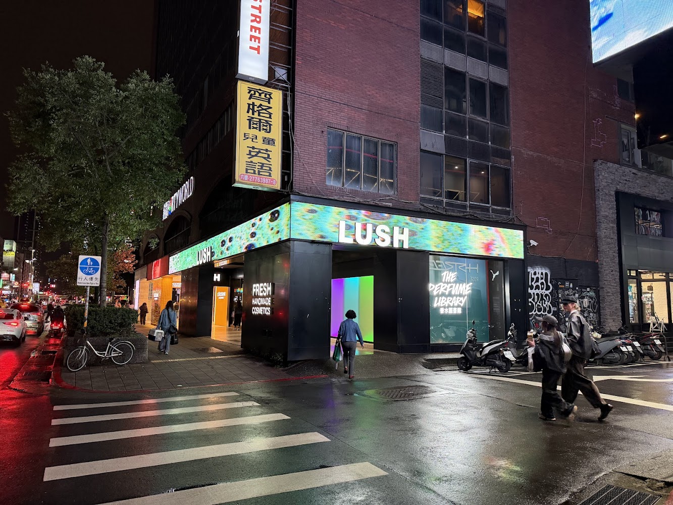 東區夜晚街頭，LUSH 門市招牌醒目、街上有行人。