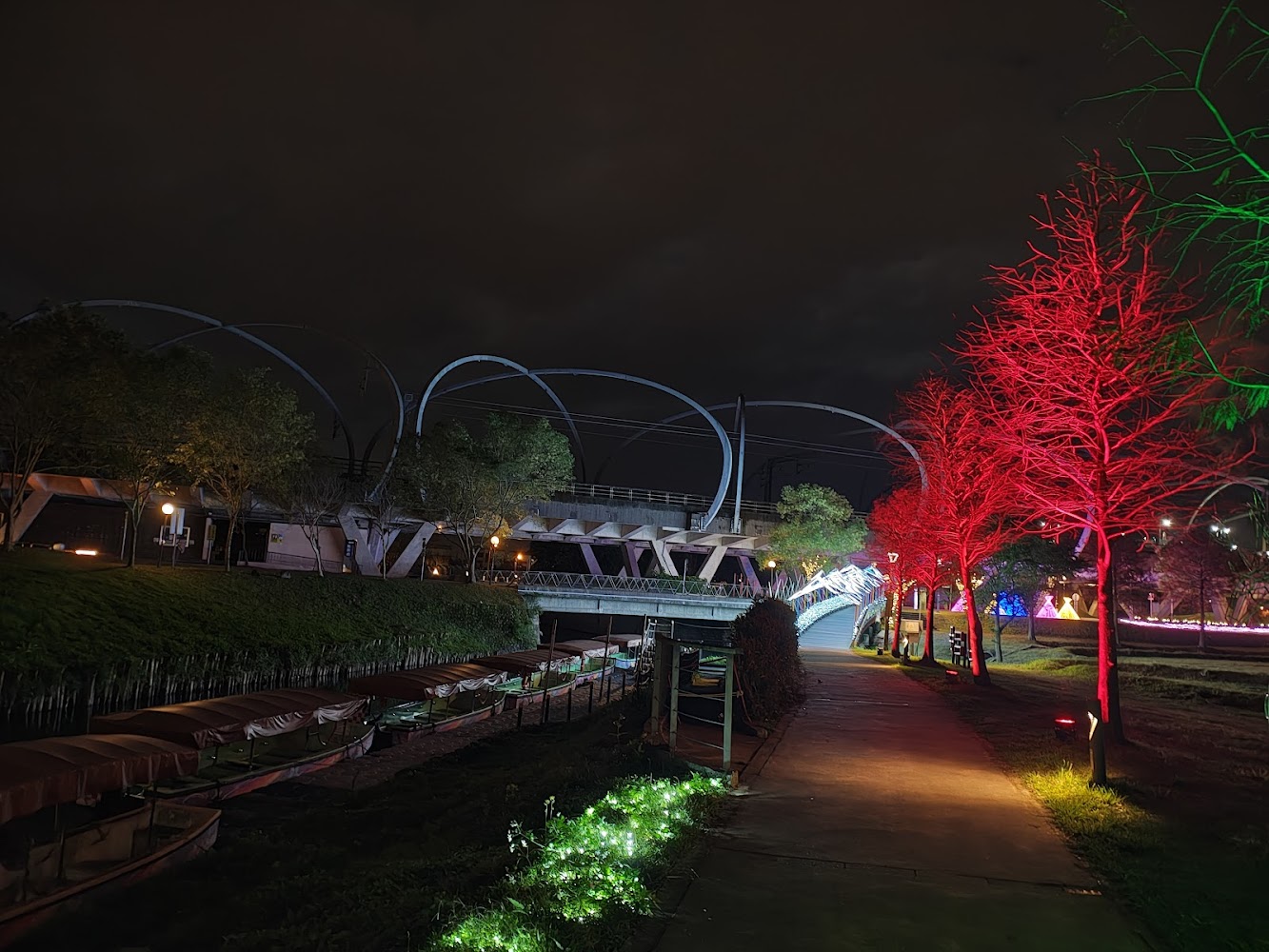 夜晚燈光橋樑與河岸步道船隻