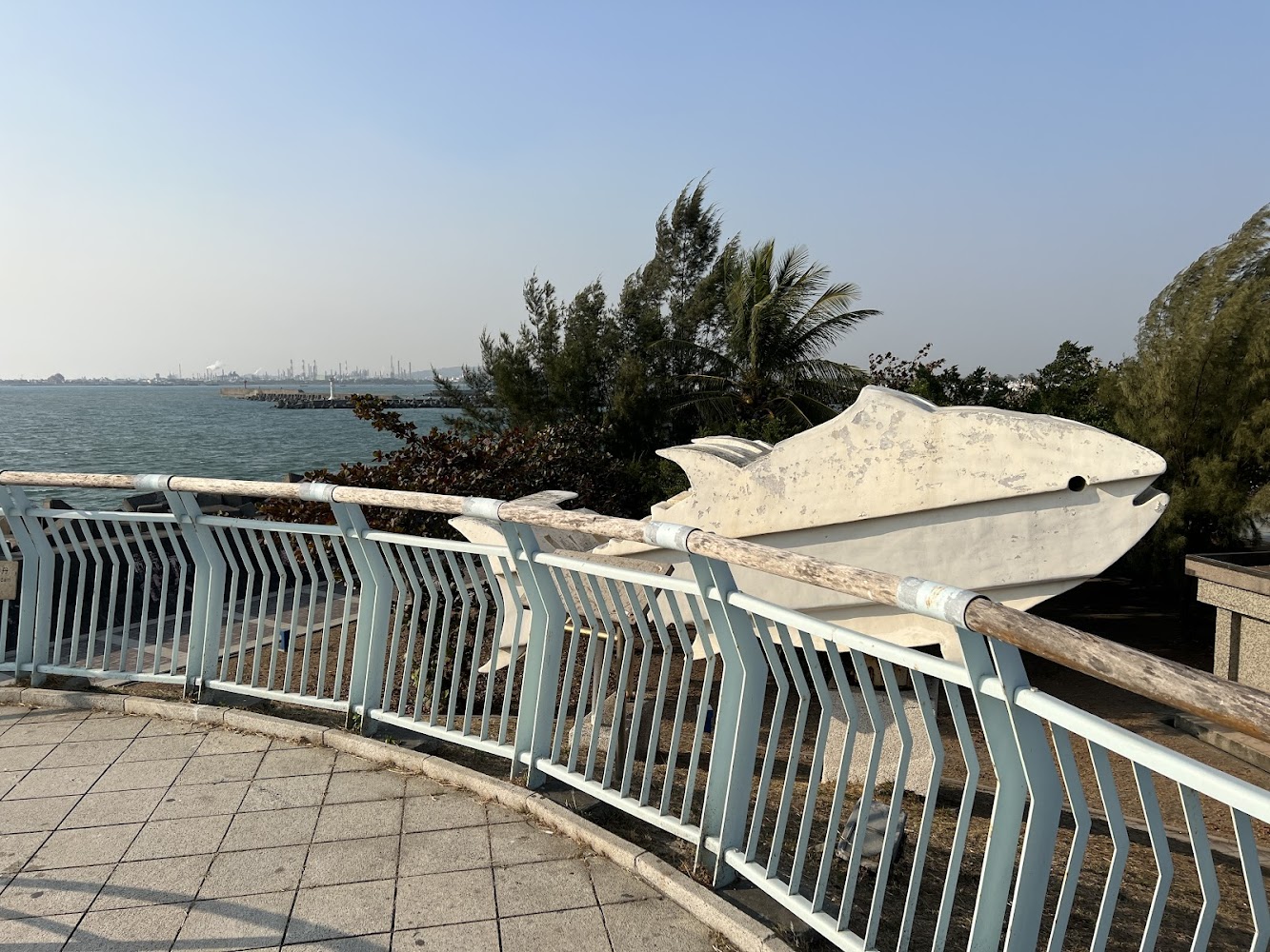 海邊景點白色大魚雕塑與藍色欄杆