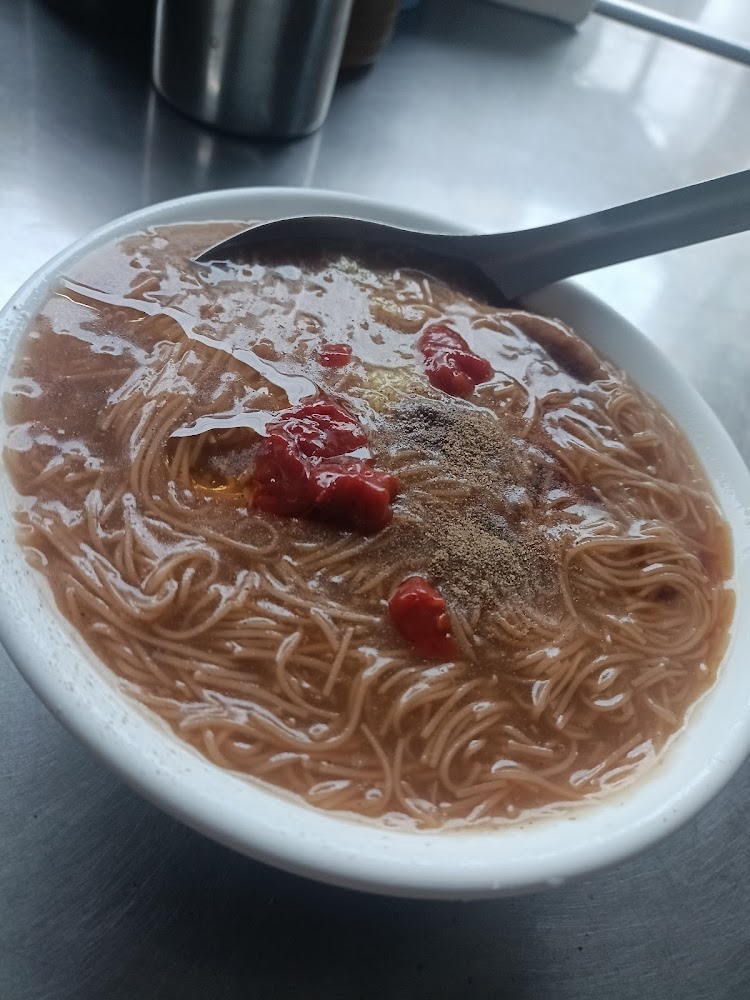 一碗麵線羹，上面加了紅色辣椒醬與胡椒粉