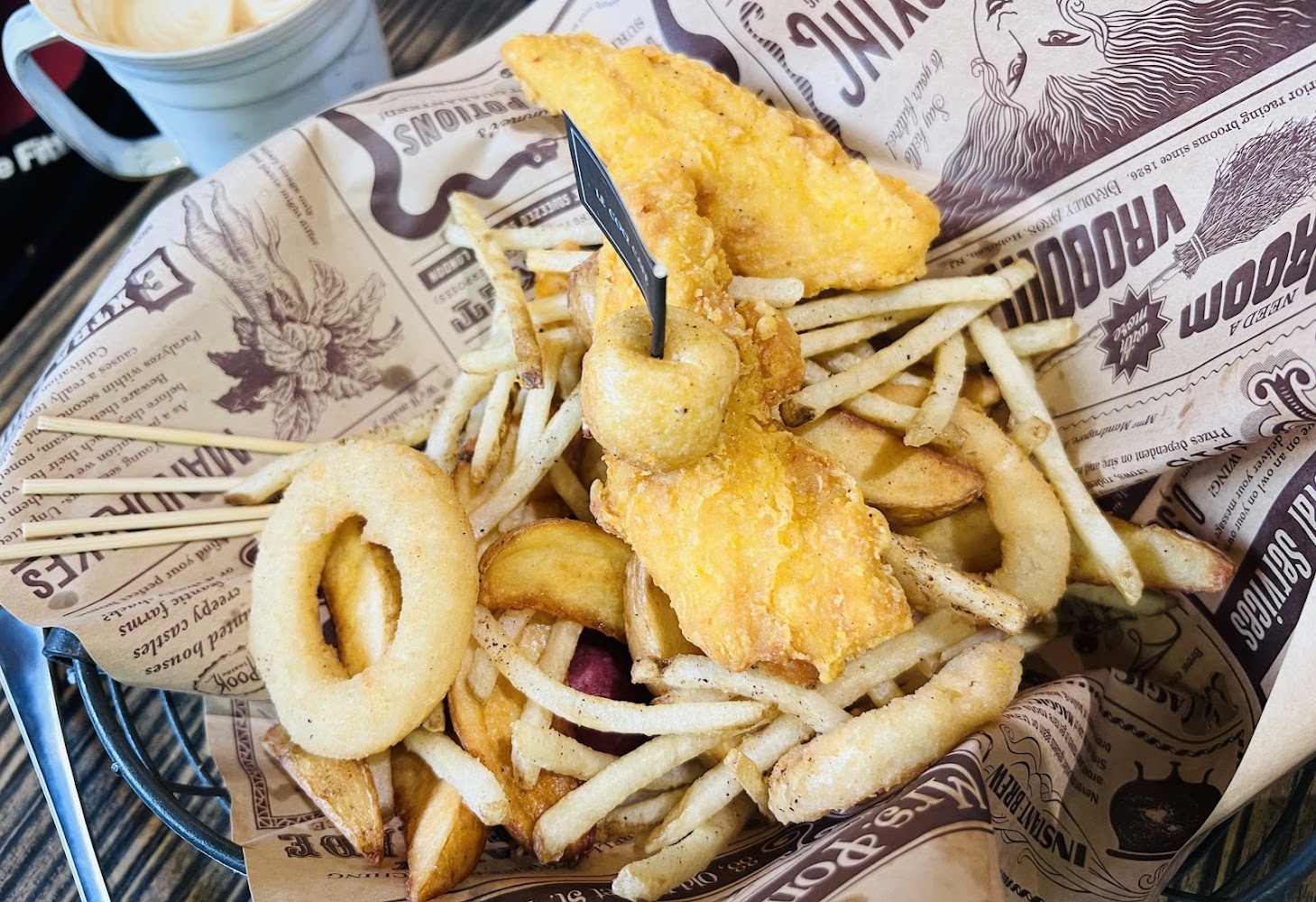 炸魚薯條搭配洋蔥圈與咖啡,屬於經典輕食炸物組合