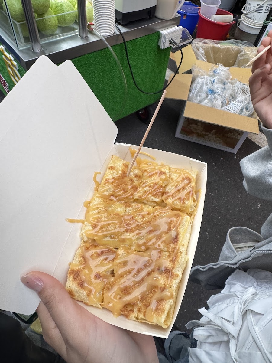 基隆廟口夜市小吃，金黃薄餅切塊淋上醬料竹籤插食