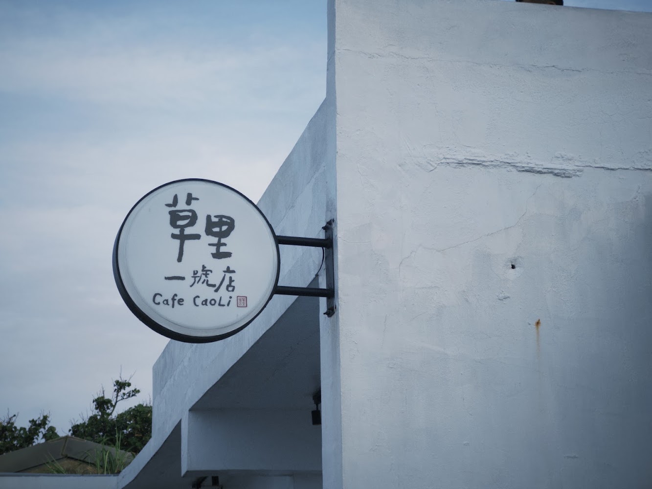 草里一號店 Cafe CaoLi 圓形招牌與白色建築外牆