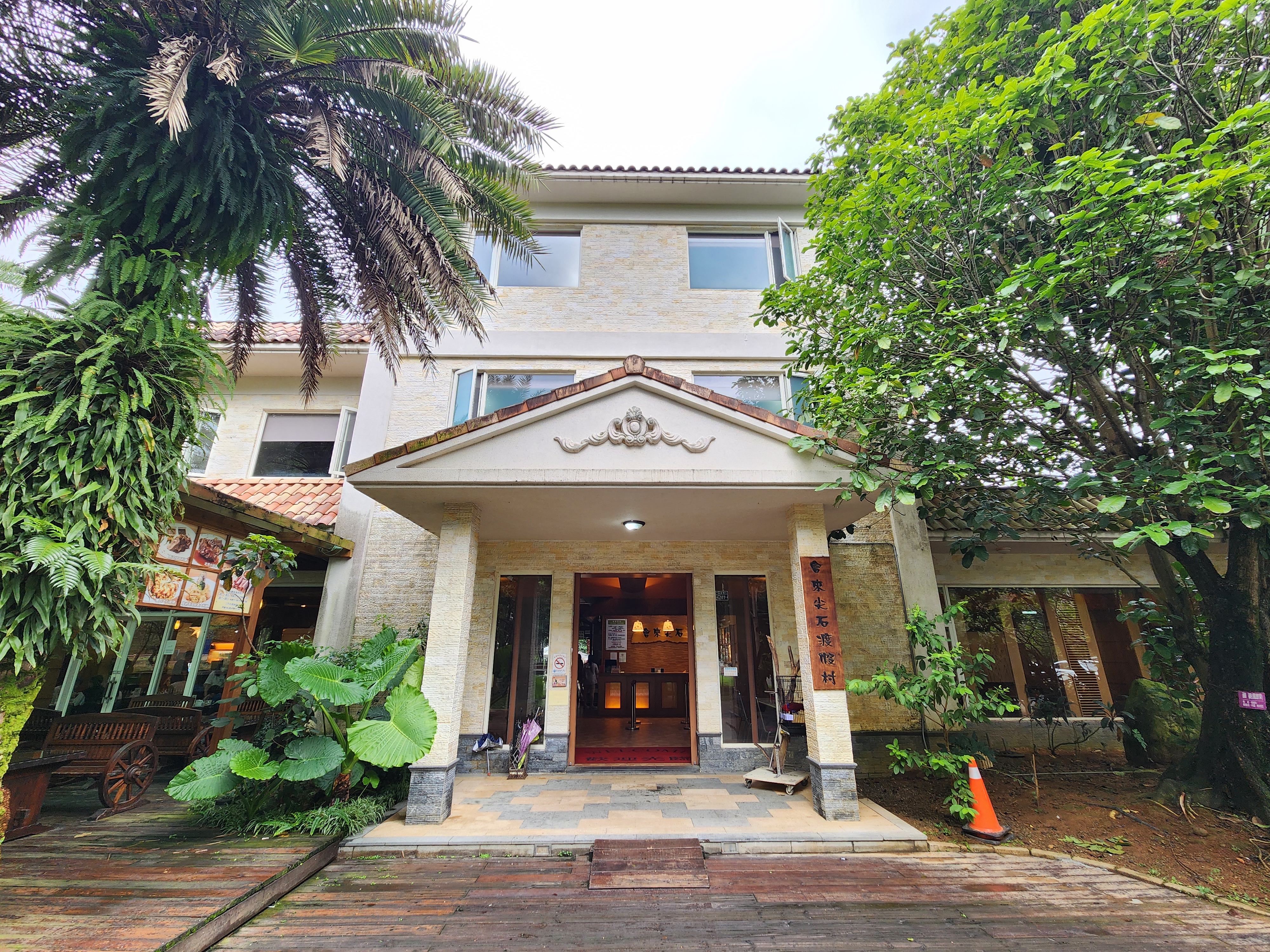 會來尖石溫泉渡假村三層樓建築與門口綠意
