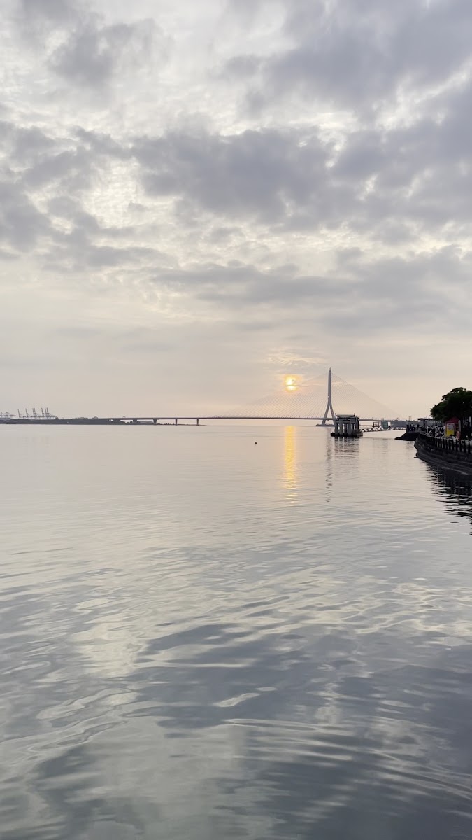 淡水金色水岸黃昏河景，遠眺情人橋斜張橋剪影，淡水河面平靜如鏡